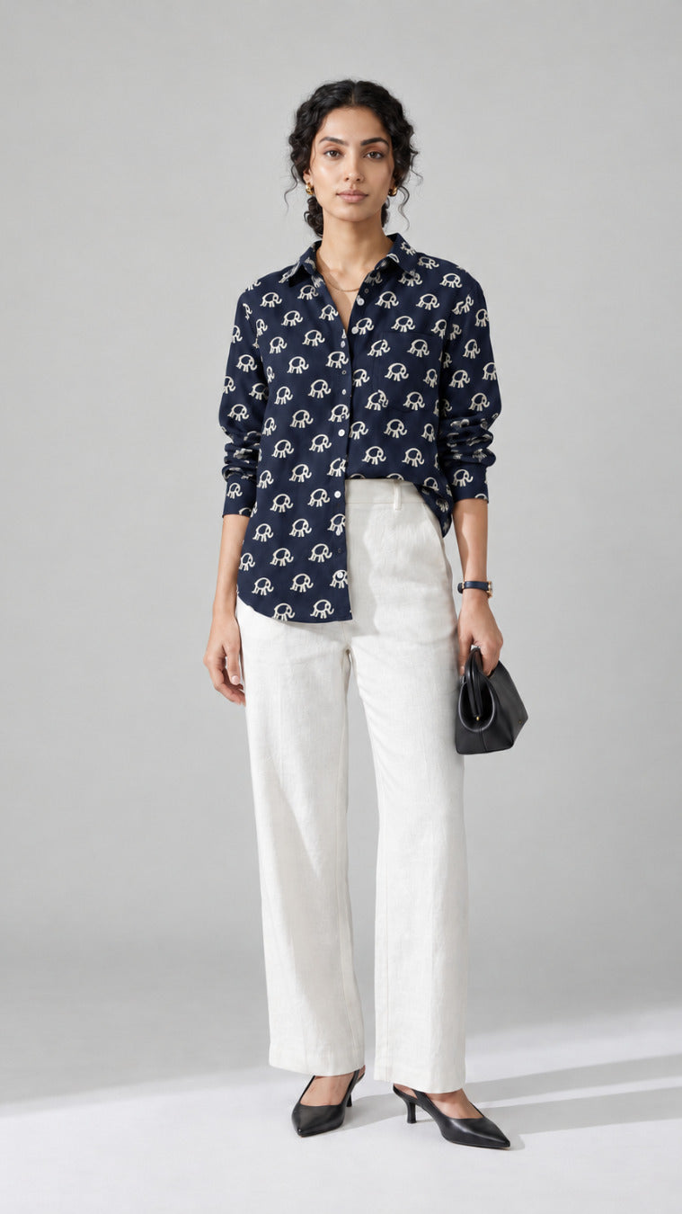 Woman wearing the navy Elephant Print pure cotton shirt with white wide-leg trousers, front view