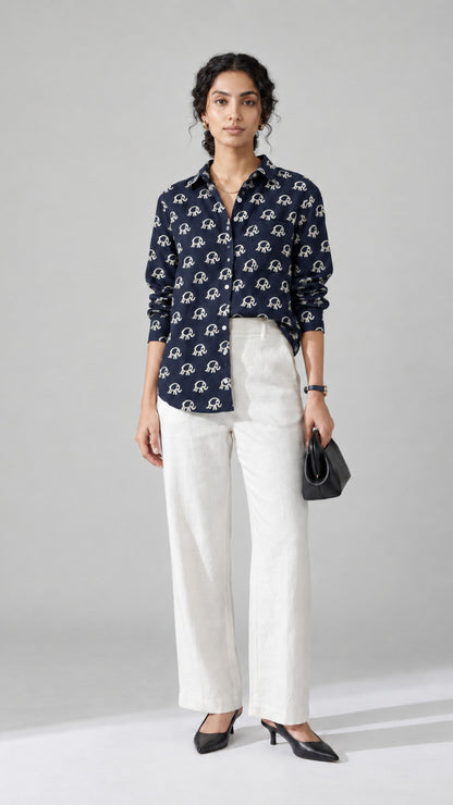 Woman wearing the navy Elephant Print pure cotton shirt with white wide-leg trousers, front view