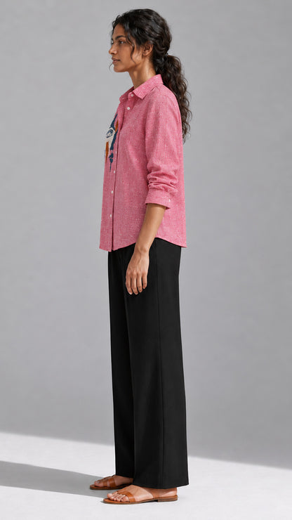 Ice red face embroidered cotton linen shirt worn with black wide-leg trousers, side view