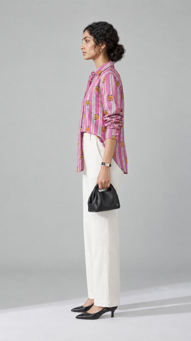 Pink stripe shirt with yellow floral print worn with ivory wide-leg trousers, side view